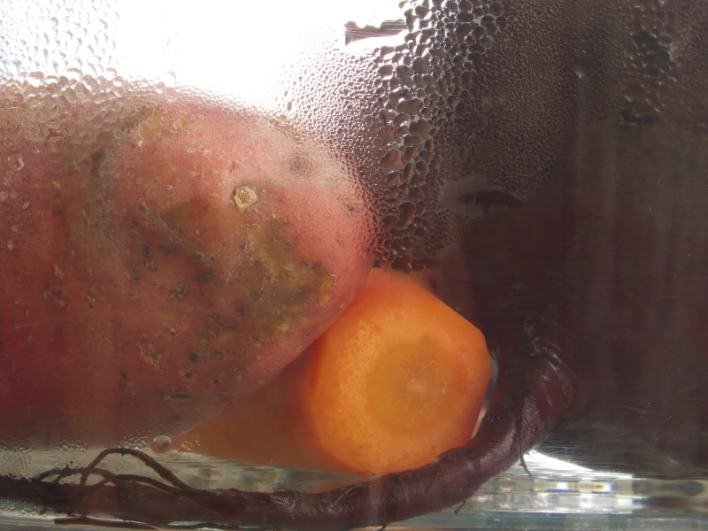 На фото картофель, морковь и свекла в прозрачной ёмкости с водой
